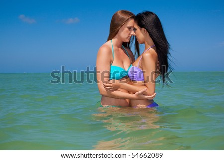 stock photo : Lesbian couple on vacation, standing in water