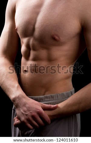 Muscular torso of a man isolated on black background
