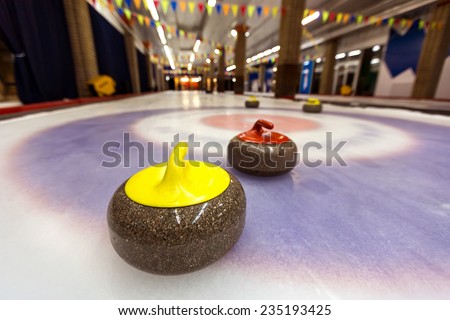 Curling stone on ice of a indoors rink