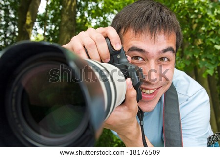 Portrait of the cheerful photographer on a background of a wood