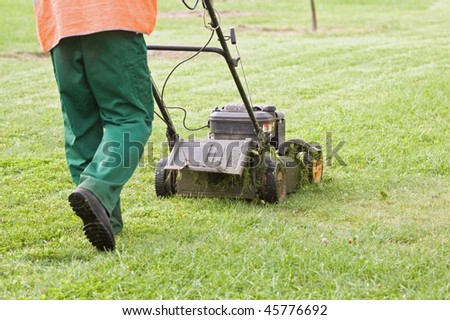 Man gardener working with lawn mower