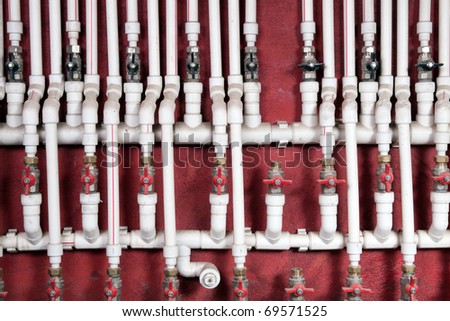 White water pipes against a red wall