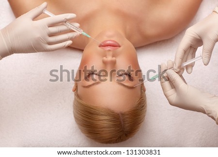 closeup portrait of cosmetic botox injection in the female face, eyebrow and lip zone