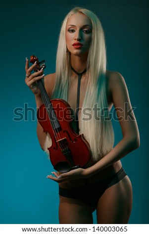 art portrait of sexy blonde with long hair holding violin against dark turquoise background