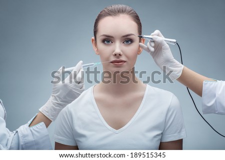 portrait of lovely young woman getting permanent makeup and injection