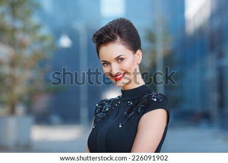 closeup portrait of happy beautiful young woman smiling against blue urban background
