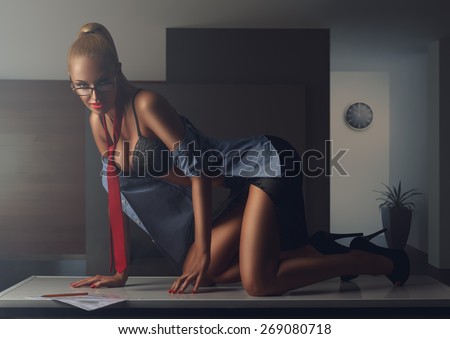 sexy office secretary in unbuttoned shirt posing on the table