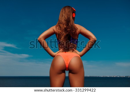 back view of sexy female ass wearing sportswear against blue sky