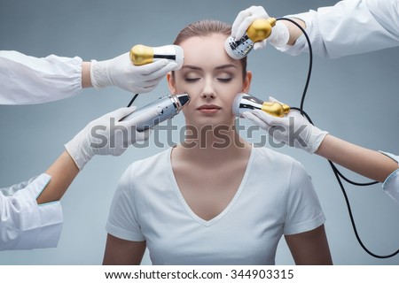 closeup portrait of lovely calm young woman with hands holding medical maniples touching her face