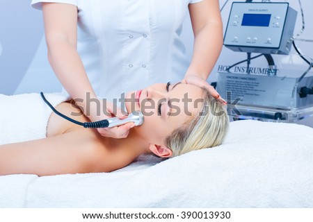 Hardware cosmetology. Closeup picture of lovely young woman with closed eyes getting rf lifting procedure in a beauty parlour.