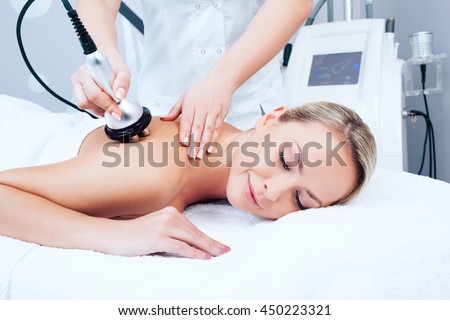 Hardware cosmetology. Picture of happy young woman getting rf lifting procedure in a beauty parlour.