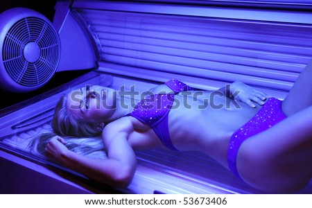 beautiful young woman tanning in solarium