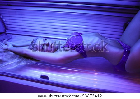 beautiful young woman tanning in solarium