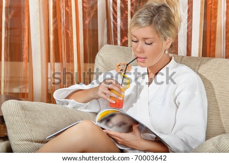 relaxed girl reading a magazine on a chair while having juice