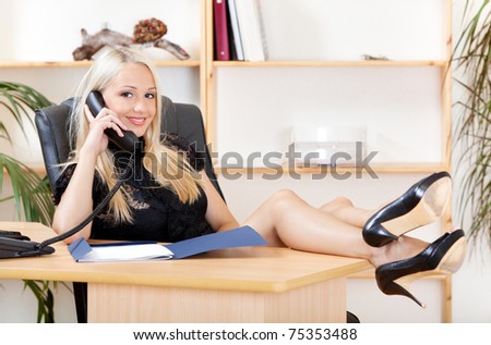 portrait of pretty young woman sitting at the table and speaking on the telephone