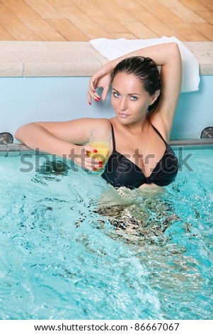 portrait of sexy young woman with juice have a good time in jacuzzi