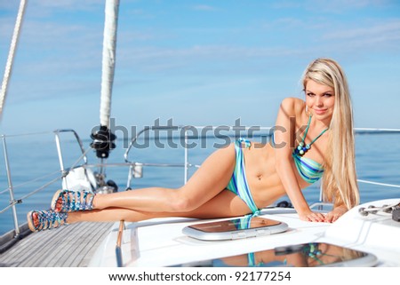 picture of sexy young woman tanning on the bow yacht