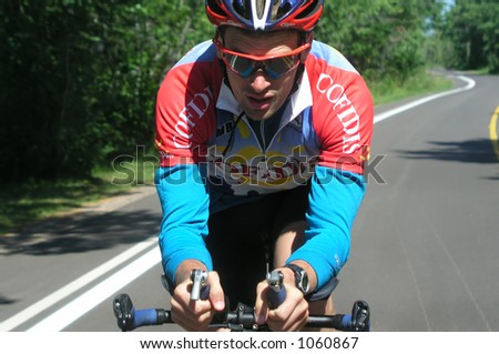 Athlete training by riding his bicycle on country road
