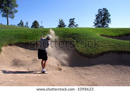 Golfer hitting out of a sand trap (3 of 3 shot action sequence)