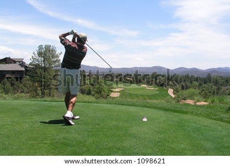 Golfer hitting golf ball off tee box on beautiful golf course