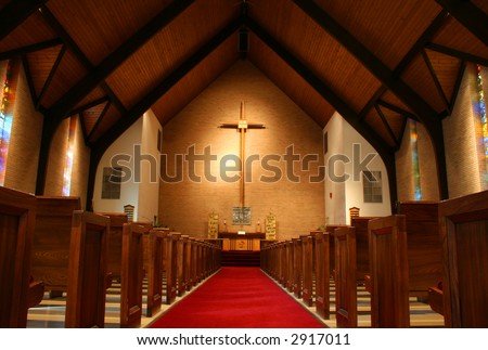 stock photo Inside of a large modern church with pews and cross visible