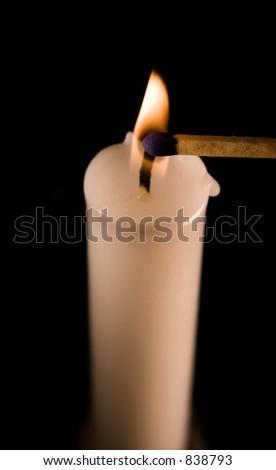 A picture of a match being ignited by a burning candle.