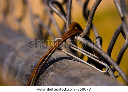 A paperclip linked to a metal chain link fence