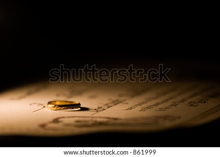 A marriage certificate with a ring lying on it