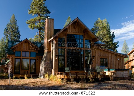 a large cabin in the mountains surrounded by trees