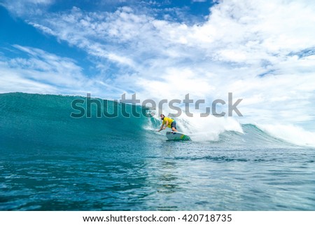 Surfer with long white hair rides by paddle board (S.U.P) in the big ocean wave in Mauritius Island, Indian Ocean