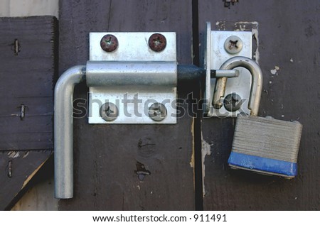 A shed door with a unlocked padlock.