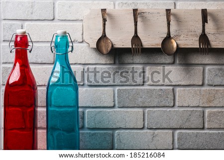 Kitchen wall with spoons and forks and colored bottles/Kitchen lifestyle brick wall/ Kitchen brick wall with colorful bottles