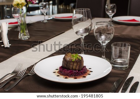 Beef steak on restaurant table with red beetroot salad/ Beef steak dinner plate / Beef steak and red beetroot salad on a plate on restaurant table setting