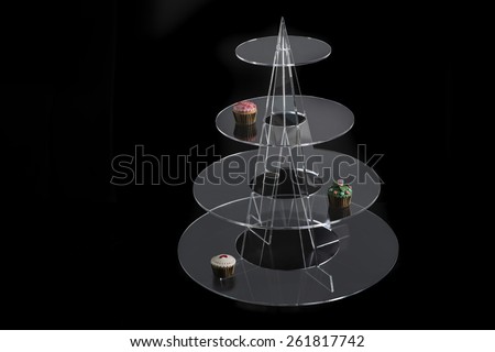 Transparent cake stand isolated on black / Cupcakes on transparent cake stand / Cake stand on black background