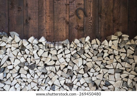 Stacked fire wood and barn wall with horse shoe/Oak wood stacked for fire/Oak tree wood stacked for fire in the barn with horse shoe