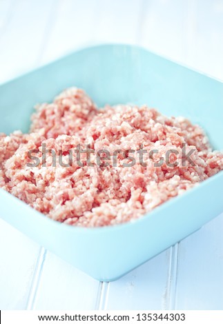 Ground pork in a bowl on a wooden table