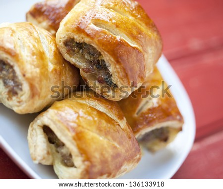 Sausage rolls on a plate on a wooden table
