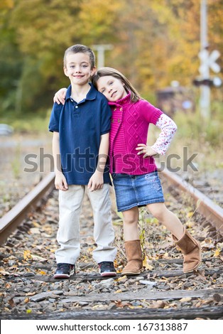 Siblings hugging on train tracks