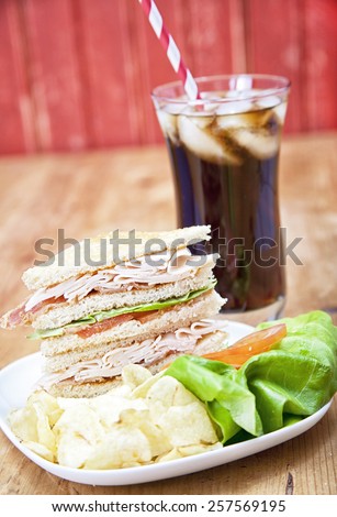 Turkey Club Sandwich with chips and soda