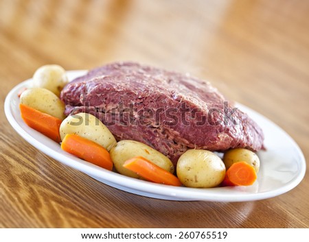 Irish St. Patricks Day meal of corned beef, potatoes and carrots on a wooden table