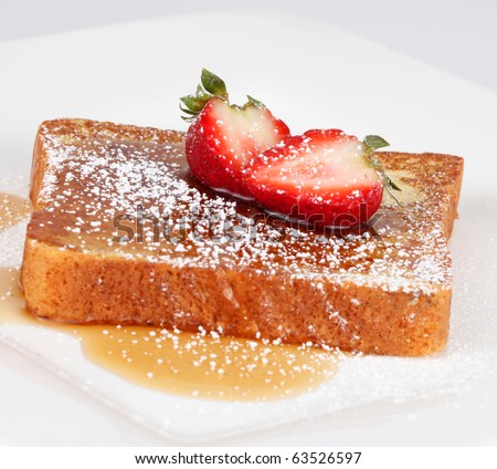 French toast with powdered sugar and a strawberry on white