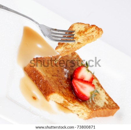 French toast with drip of syrup and strawberries on white background