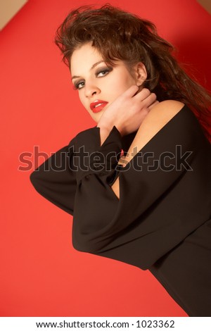 Beautiful model in a black fashionable blouse. background  is red