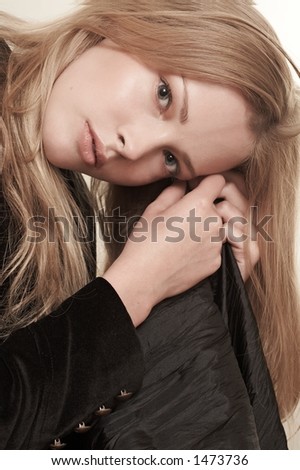 Fashion portrait of a girl with beautiful long hair. The photo is made in pastel beige tones.