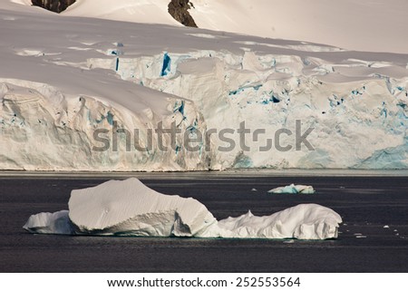 Long white iceberg off the coast of Antarctica covered with snow and ice