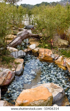 stock photo Coy fish pond with rocks and vegetation