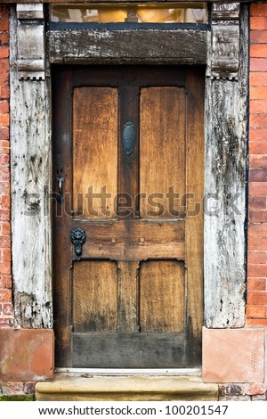 Old Oak door, frame, and window of tudor building.