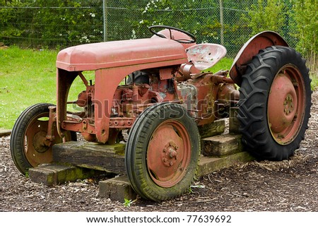 A rusty old farm tractor sits alone on stacked wooden railway sleepers a reminder of our past farming heritage