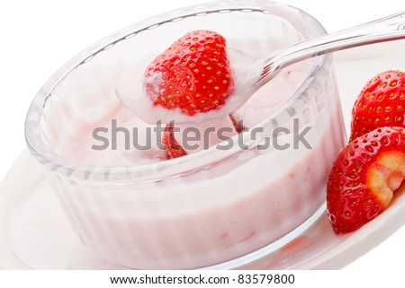 Strawberry yogurt with fresh strawberries in a glass bowl on a white plate with spoon on white background.