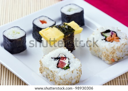 Vegetable Sushi Rolls. Traditional Japanese food on white dish with bamboo mat and red table napkin.